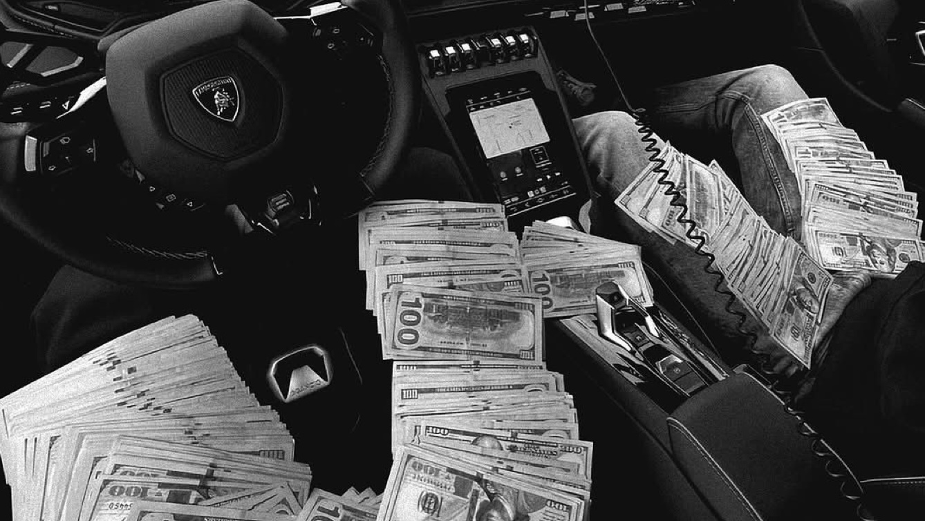 Stacks of hundred dollar bills across a Lamborghini interior